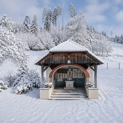 A picturesque, snow-covered chapel on the farmhouse grounds, surrounded by an idyllic winter landscape.