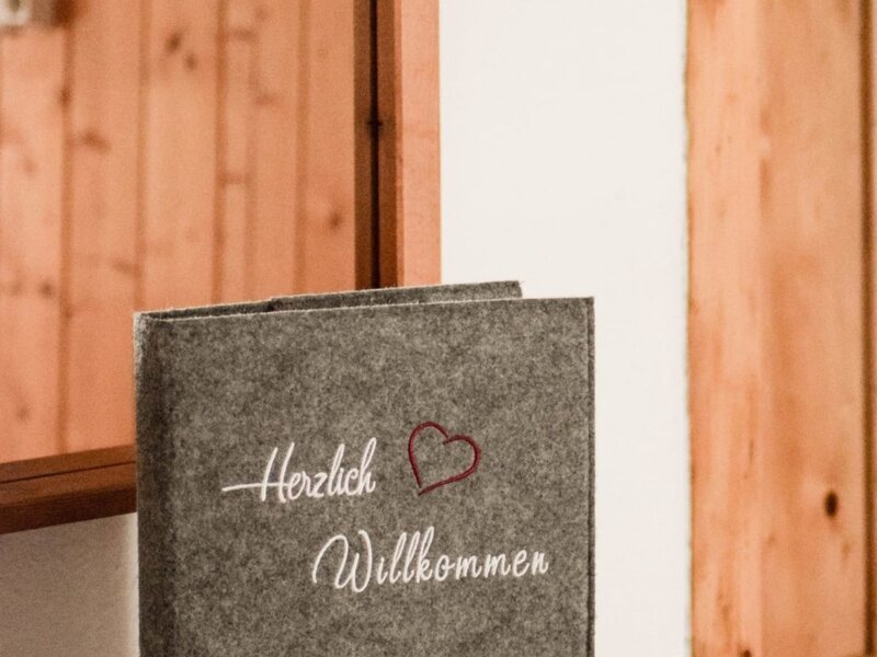 Welcome book for guests of the farmhouse, inscribed with 'Herzlich Willkommen' and the 'Urlaub am Bauernhof' logo.