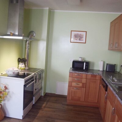 The farmhouse kitchen features a traditional-style range cooker with an extractor hood, microwave, toaster, sink, and wooden cabinetry.