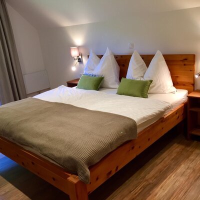 Bedroom in the farmhouse featuring a Swiss pine double bed and balcony access.