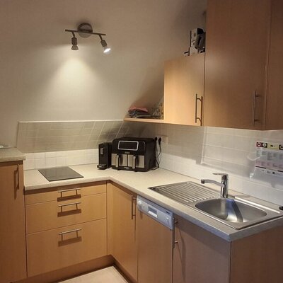 Kitchen in the farmhouse with a sink, induction hob, dishwasher, and coffee machine.