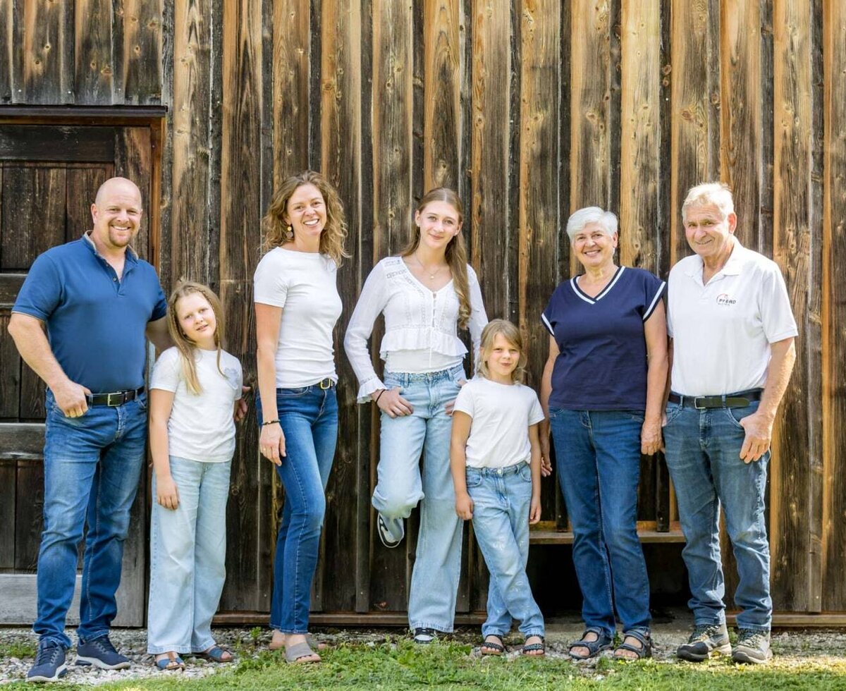 The welcoming hosts of the farmhouse standing in front of a rustic wooden facade.
