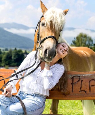 A gentle moment with one of the friendly horses at the farmhouse, set against a scenic mountain backdrop.