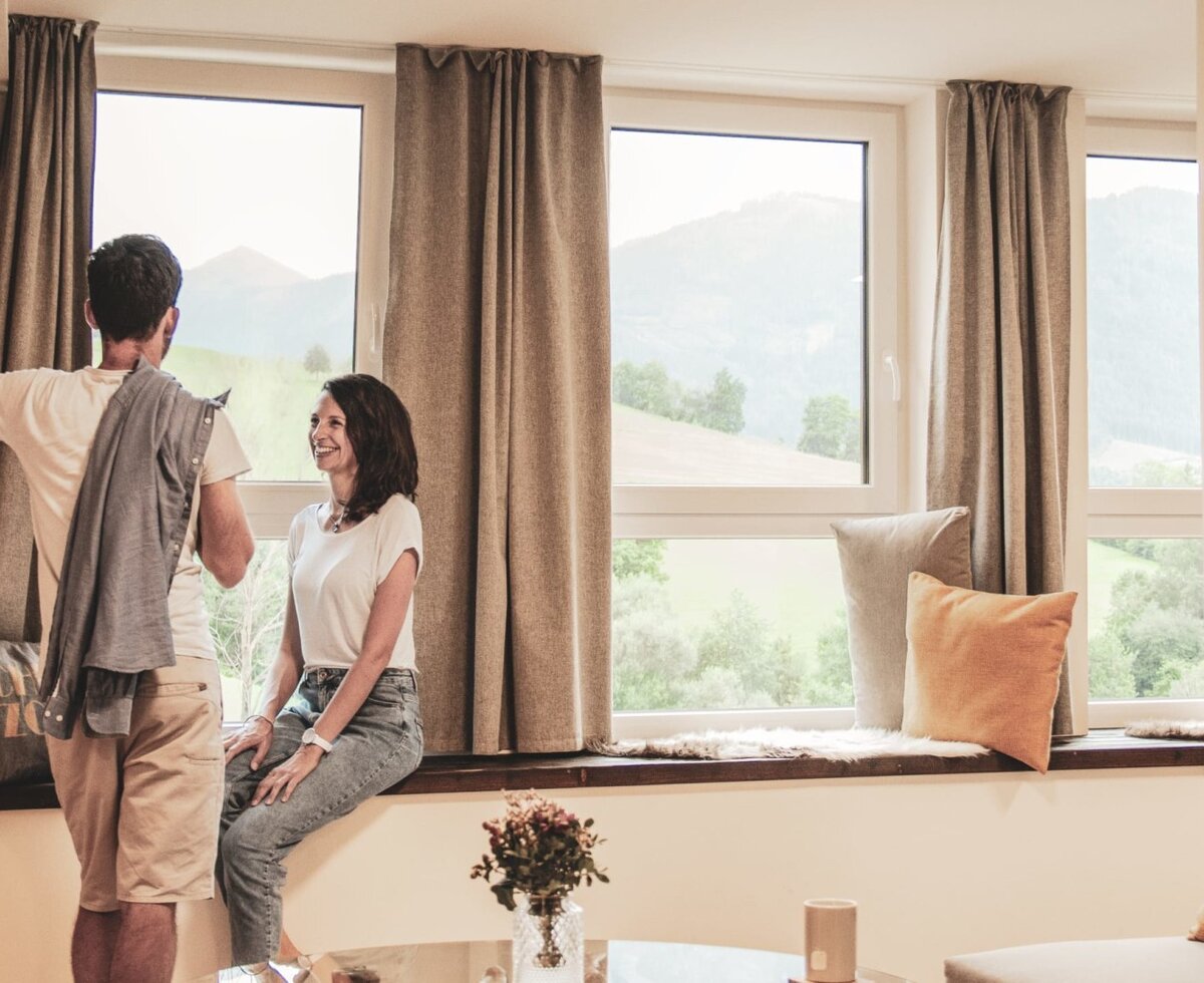 An inviting window seating area in the farmhouse, featuring cozy cushions and a scenic view of the surrounding mountains.