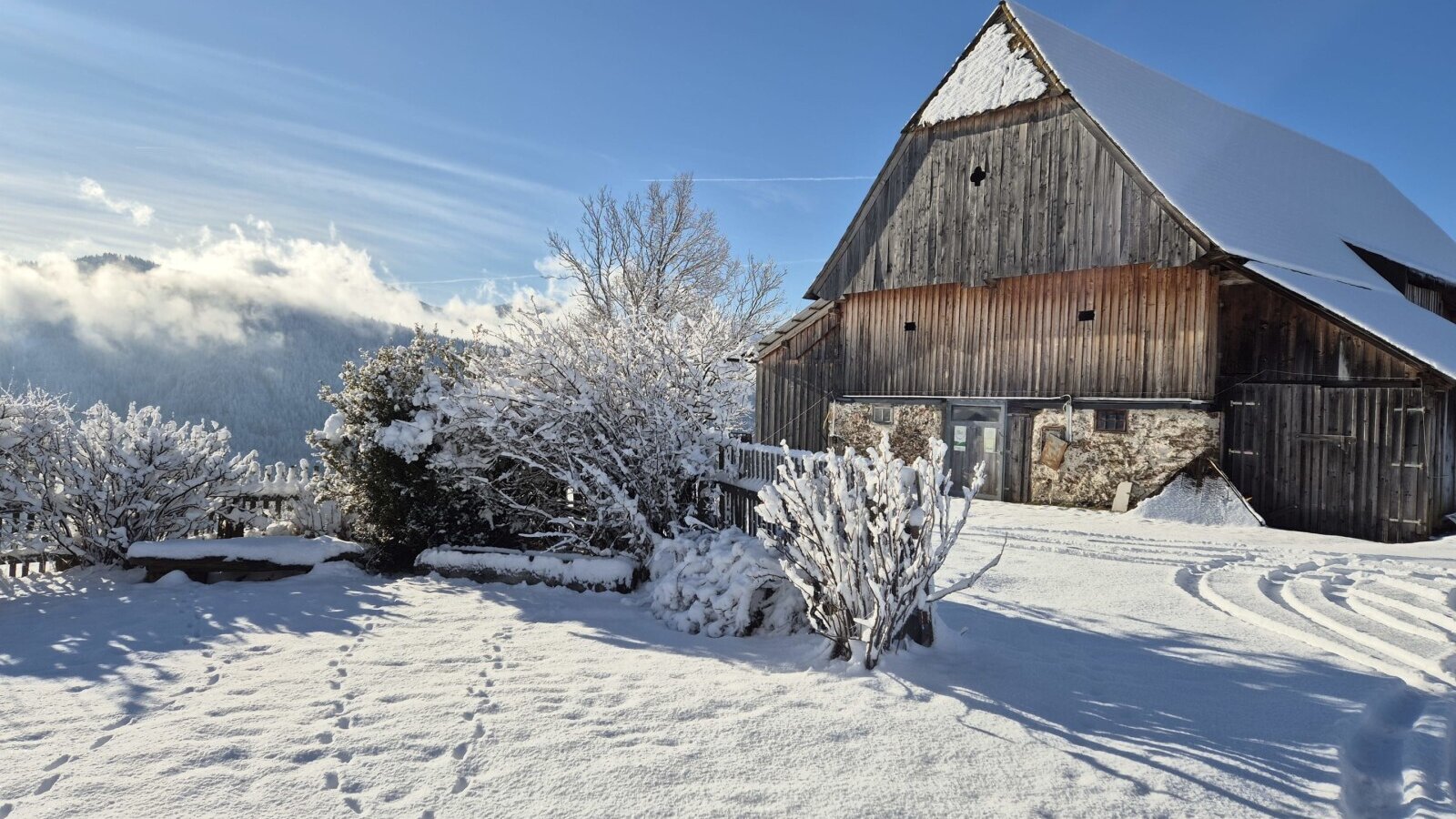 The snow-covered alpine stable of the Grünalm in a winter mountain landscape.