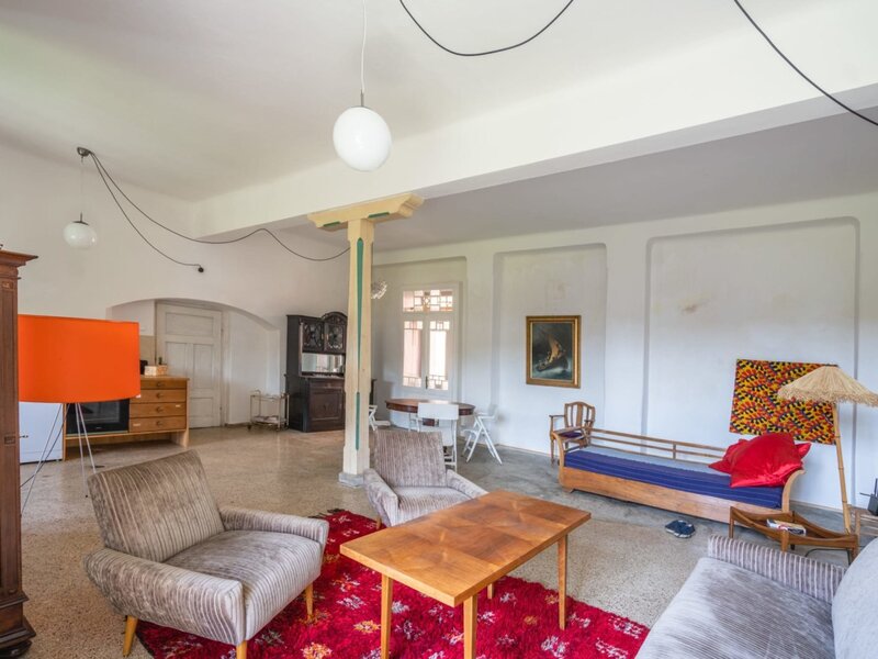 The apartment's spacious living area, featuring cozy retro armchairs, a wooden coffee table, and an inviting, artistic atmosphere.