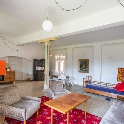 The apartment's spacious living area, featuring cozy retro armchairs, a wooden coffee table, and an inviting, artistic atmosphere.