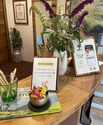 Farmhouse reception area displaying information about riding lessons and social media channels.