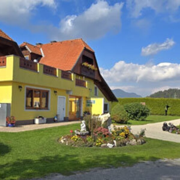 The farmhouse's well-maintained grounds with an inviting garden, green lawn, and views of the surrounding countryside.