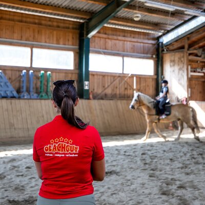 Indoor riding arena at the farmhouse with a child