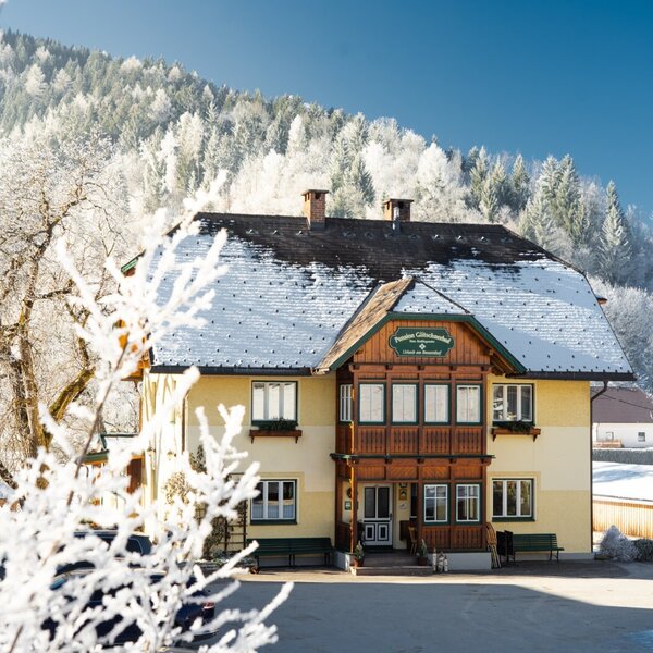 The exterior of the Farm House, featuring a snow-covered roof and a winter landscape with frosted trees and mountains. The exterior of the Farm House, featuring a snow-covered roof and a winter landscape with frosted trees and mountains.