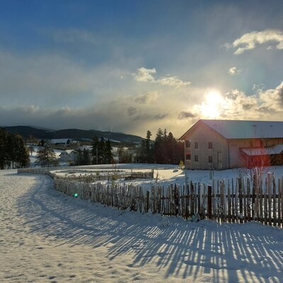 The Farm House and its snow-covered grounds, with a pond and rolling countryside in winter.