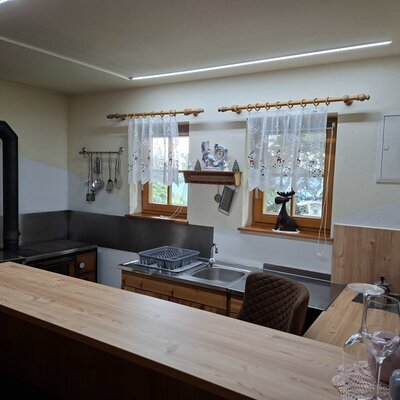 The Bed and Breakfast kitchen features a wooden countertop, sink, traditional stove, and coffee machine.