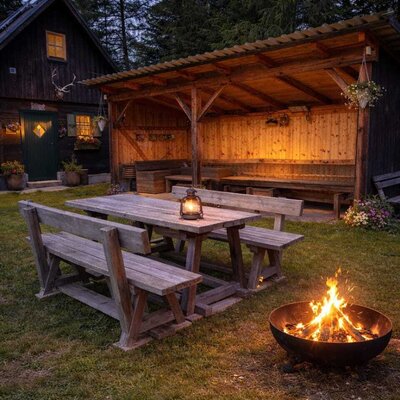 The Bed and Breakfast's outdoor area features a wooden picnic table, a covered seating space, and a fire pit.