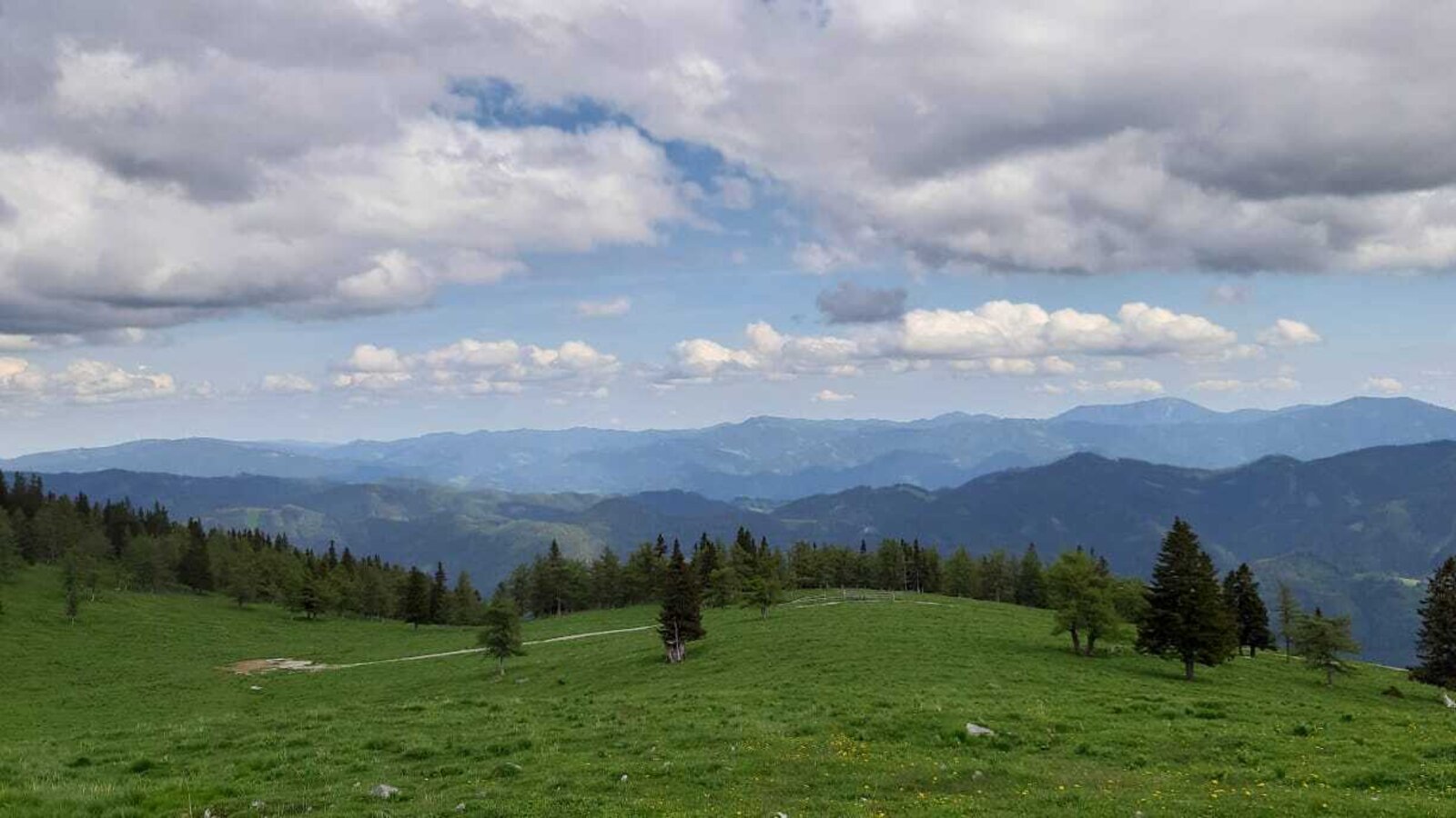 Panoramic mountain views with green hills and forests surrounding the farmhouse.
