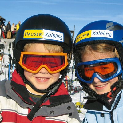 Two children in ski helmets and goggles, highlighting winter sports activities available for guests of the farmhouse.