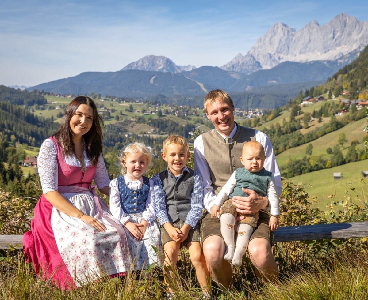 The farmhouse's welcoming host family set against the scenic backdrop of the Dachstein Mountains.