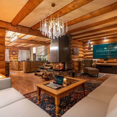 The cozy living area of the holiday home featuring rustic log walls, an inviting fireplace, and comfortable sofas.