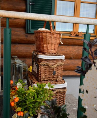 The inviting entrance of the Ferienhaus, decorated with charming wicker baskets and autumnal potted plants.