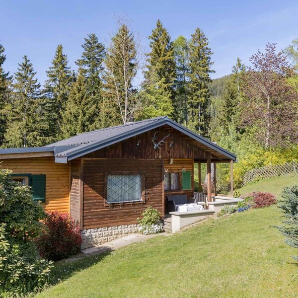 Exterior view of the Bed and Breakfast with a wooden facade, porch, and surrounding nature.
