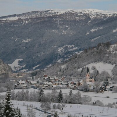 A snow-covered village and mountains in the scenic area surrounding the holiday house.