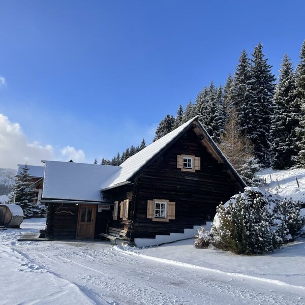 The snow-covered hut with the Finnish outdoor sauna.