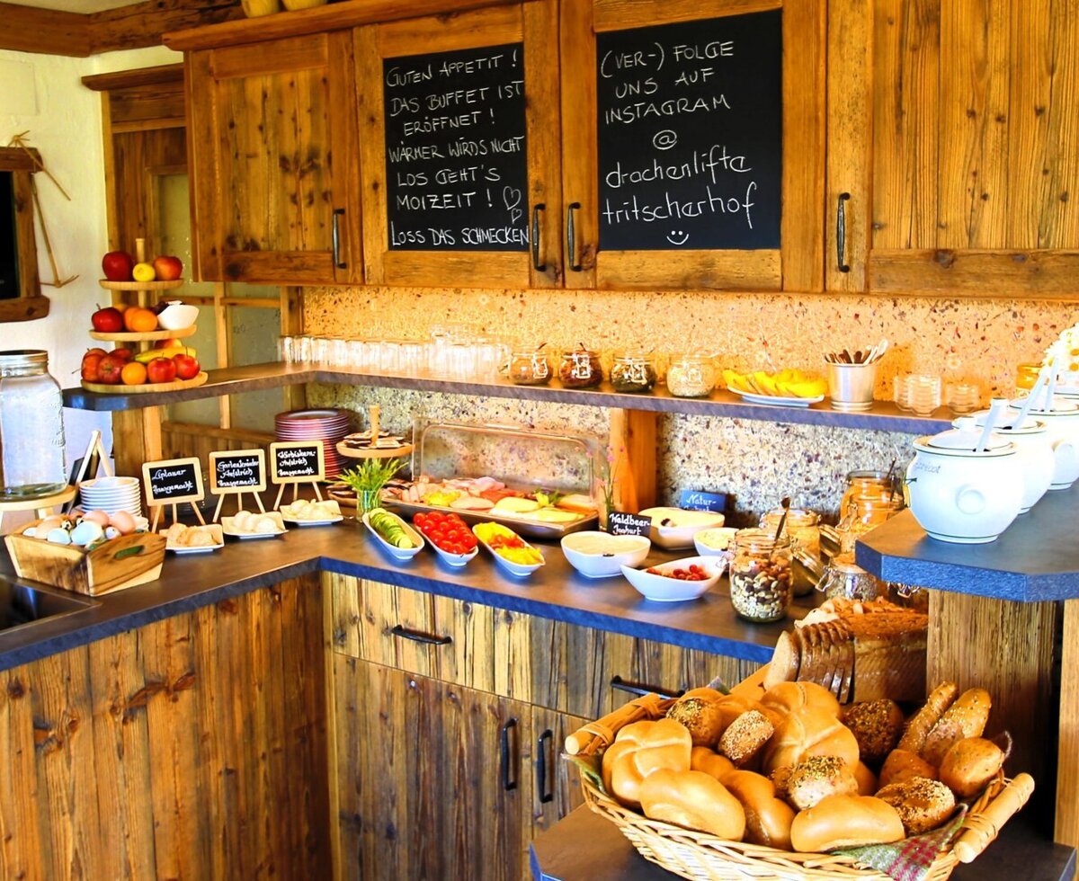 The self-service breakfast buffet at the Farm House, featuring a selection of bread, fruits, cold cuts, and cereals.