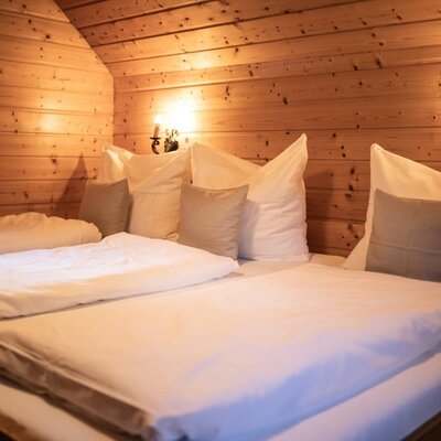 Bedroom in the Troadkasten featuring family-bed, wooden paneling, and wall-mounted lamps.