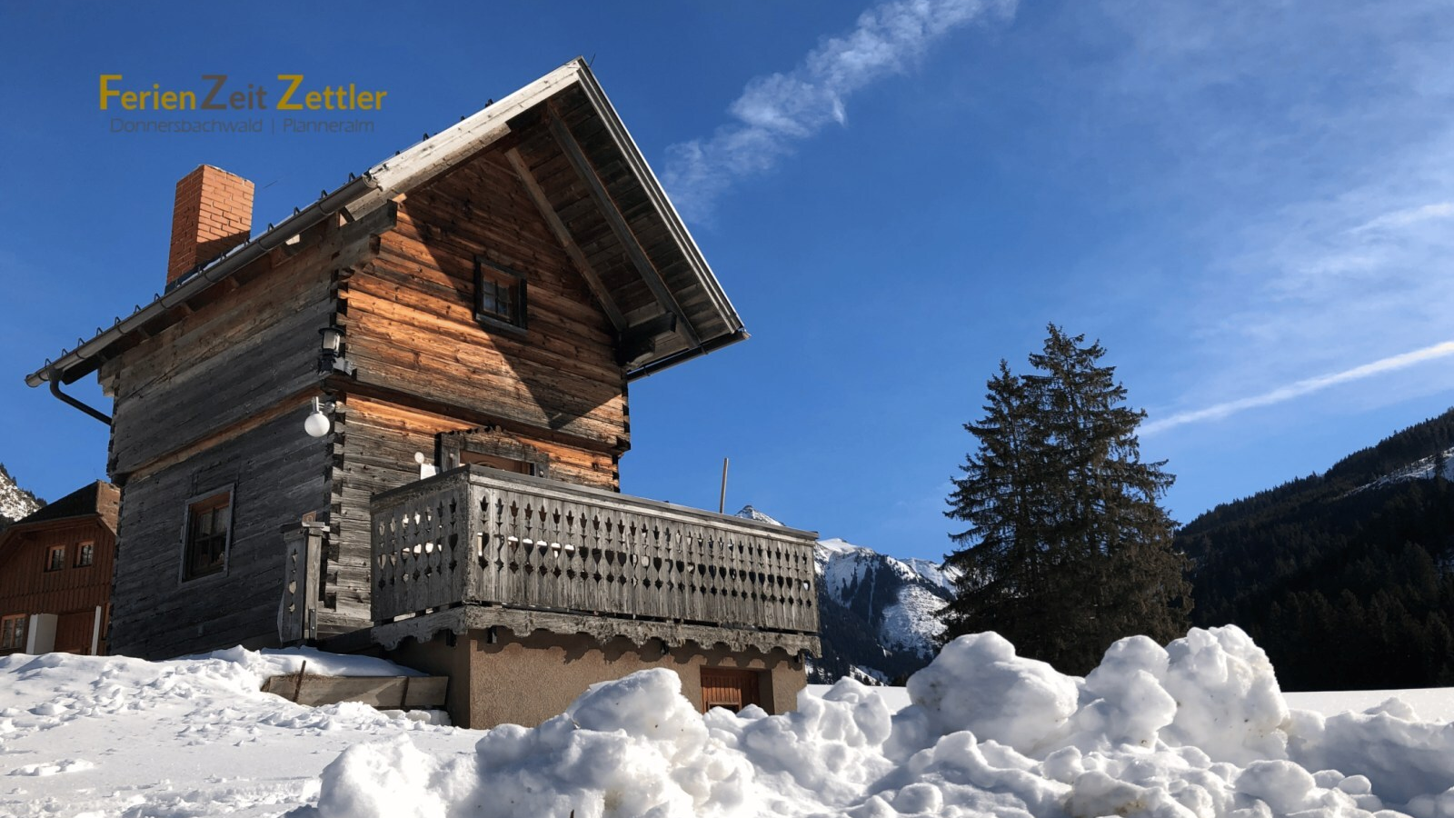 The Troadkasten with a balcony, surrounded by snow and mountains.