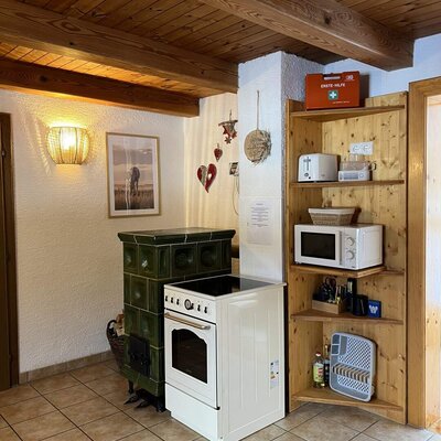 Ap­par­te­ments kitchen with a tiled stove, microwave, and toaster.