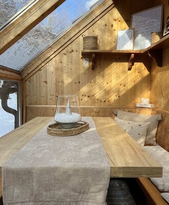 The apartment's winter garden featuring a dining table, bench seating.