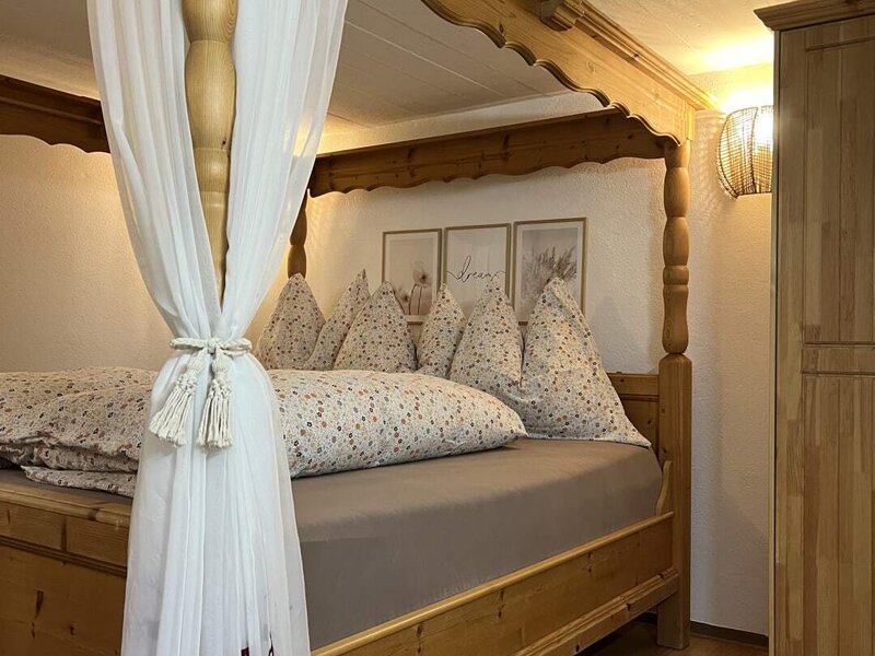 Bedroom in the Ap­par­te­ments with a pine four-poster beds