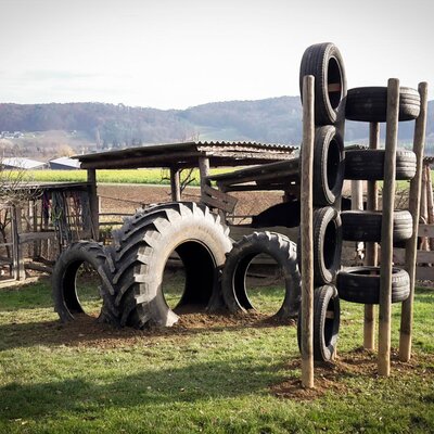 Outdoor playground at the Farm House with large tractor tires for tunnels and smaller tires stacked for climbing.