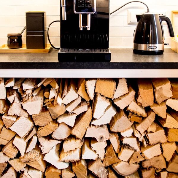 A coffee machine and electric kettle are available in the farmhouse, with firewood neatly stacked below the counter.