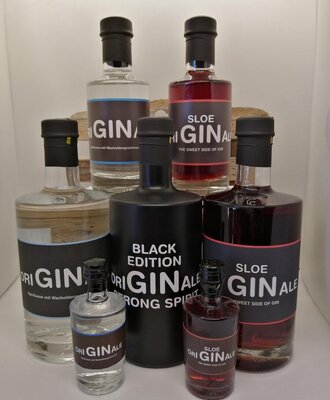 A selection of Originale Gin and Sloe Gin bottles, including the Black Edition, in various sizes.