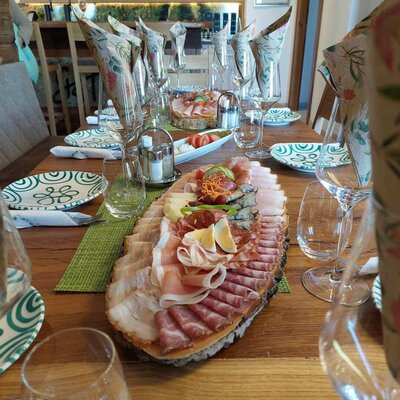 The dining table in the Haus, set with a large platter of cold cuts including meats, cheeses, eggs, and vegetables.