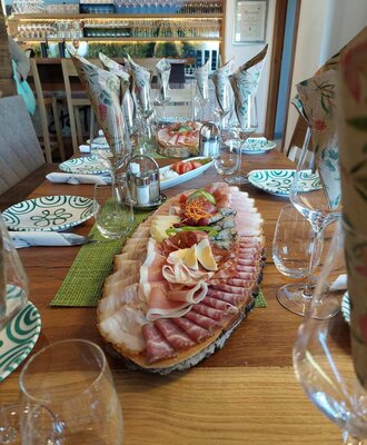 The dining table in the Haus, set with a large platter of cold cuts including meats, cheeses, eggs, and vegetables.
