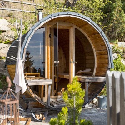 The Bed and Breakfast's outdoor barrel sauna, featuring a wooden construction, glass front, and interior benches.