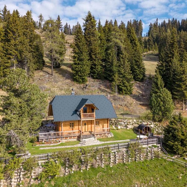 Exterior view of the Bed and Breakfast, a wooden house with a terrace and barrel sauna, located at the edge of the forest.