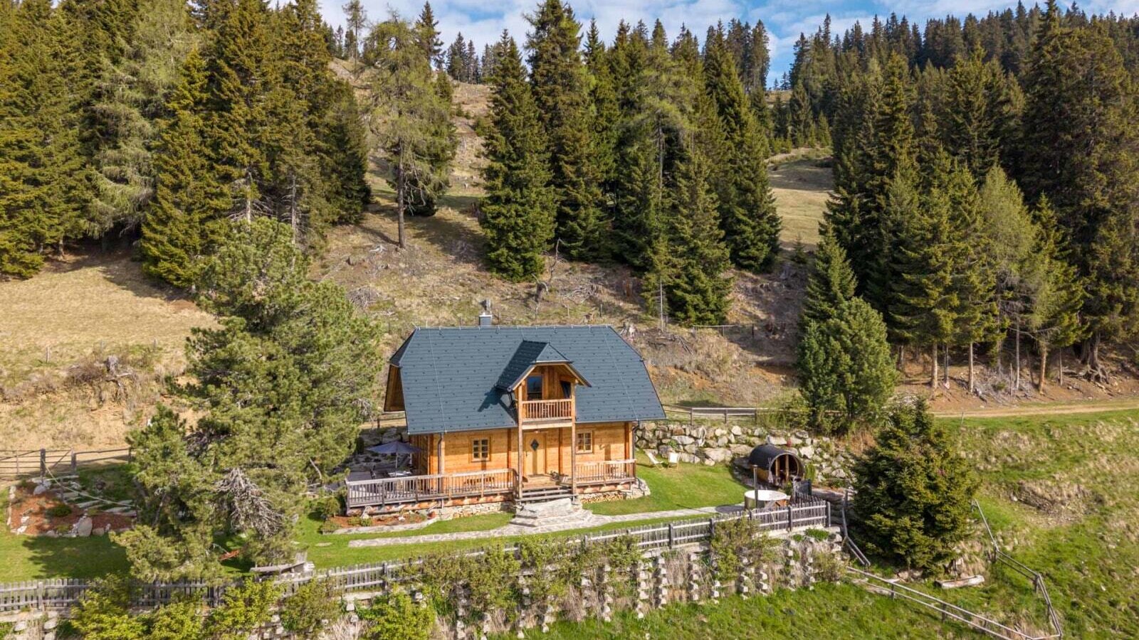 Exterior view of the Bed and Breakfast, a wooden house with a terrace and barrel sauna, located at the edge of the forest.