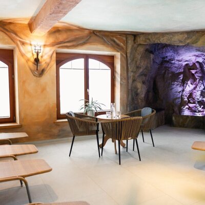 Relaxation area in the wellness area with loungers, seating, and the so-called "Kunerngrotte" in the background.