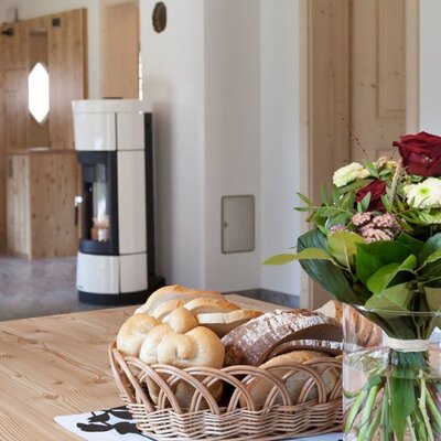The apartment's inviting dining area with a rustic wooden table, a fresh flower bouquet, and a cozy fireplace in the background.