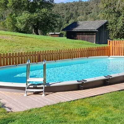 An inviting outdoor pool in the apartments' well-kept garden, surrounded by green meadows.