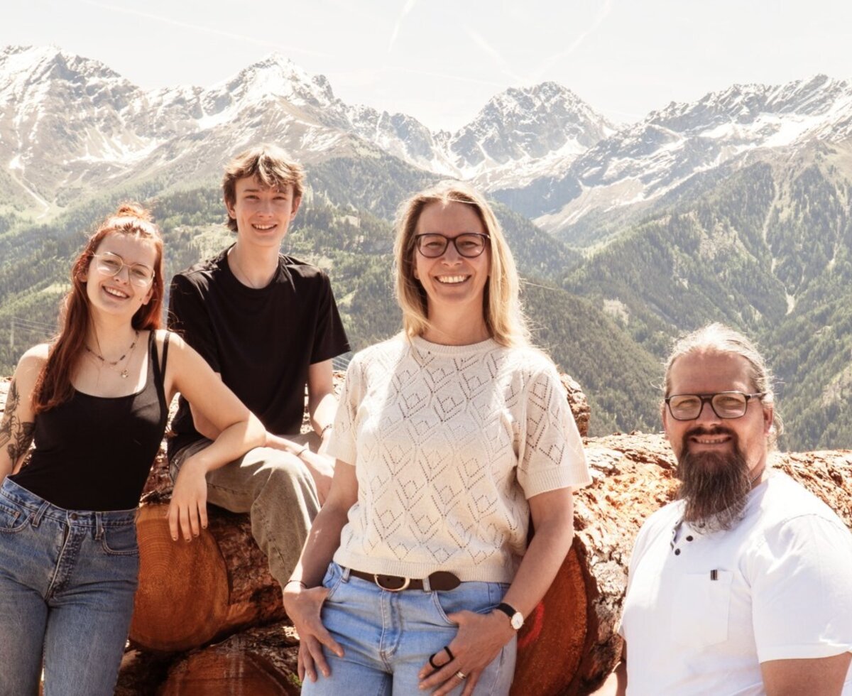 The hosts of the Farm House pictured with the surrounding mountain landscape.