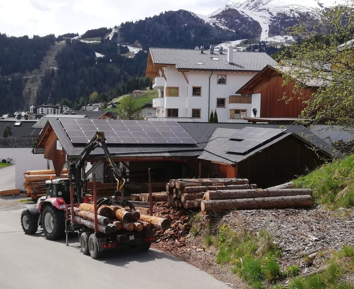 The active farmhouse with traditional woodwork set against a scenic mountain backdrop.