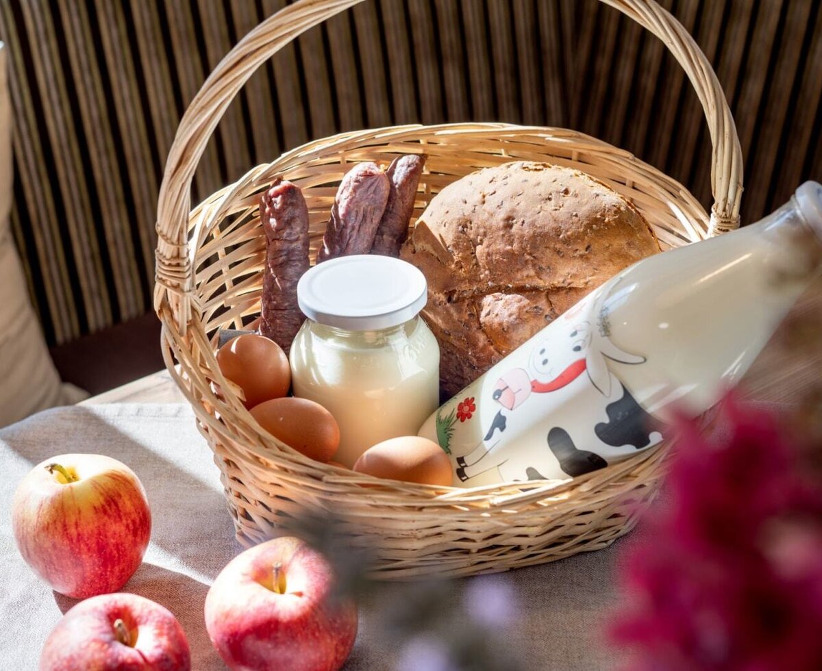An inviting basket at the farmhouse, filled with fresh, home-grown products like milk, bread, and eggs.