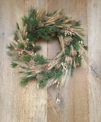 A welcoming wreath, crafted from natural pine, wheat, and dried accents, adorns the Farm House.