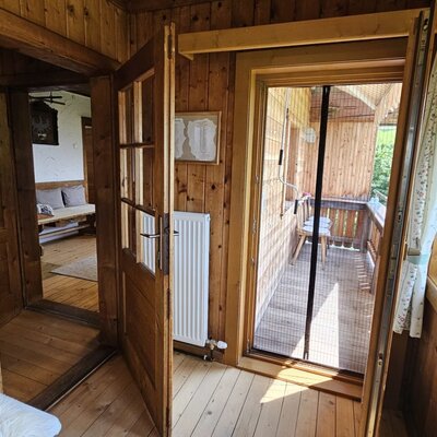 The rustic wooden interior  featuring direct access to a sunny balcony.