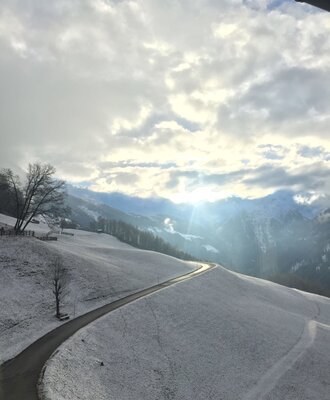 View of the snow-covered mountains and a winding road from the Farm House.