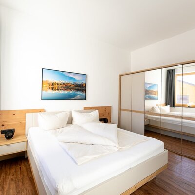Bedroom of the Ferienwohnung with a double bed, bedside tables, and a mirrored wardrobe.